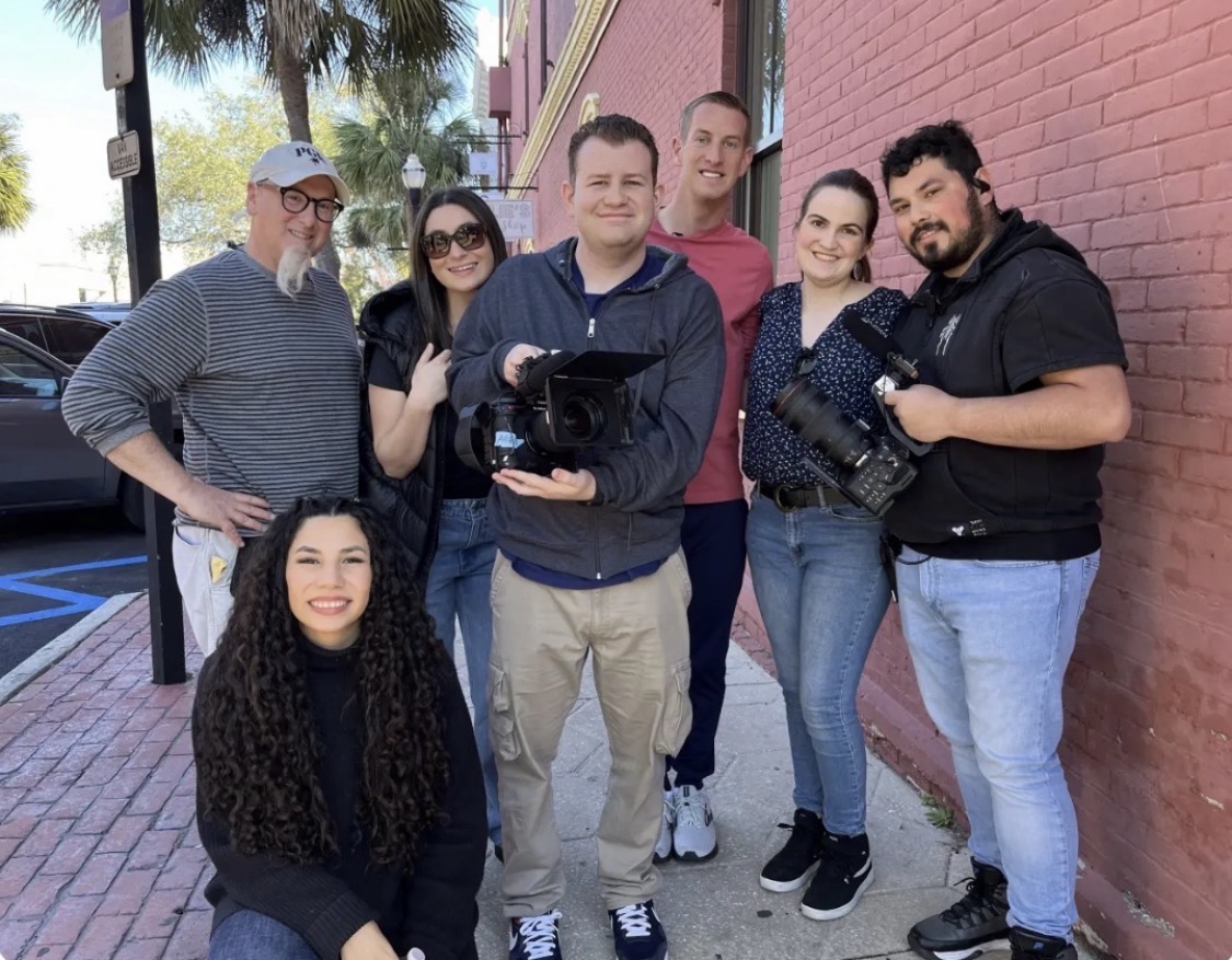 Stephen holding a camera with the film crew on location