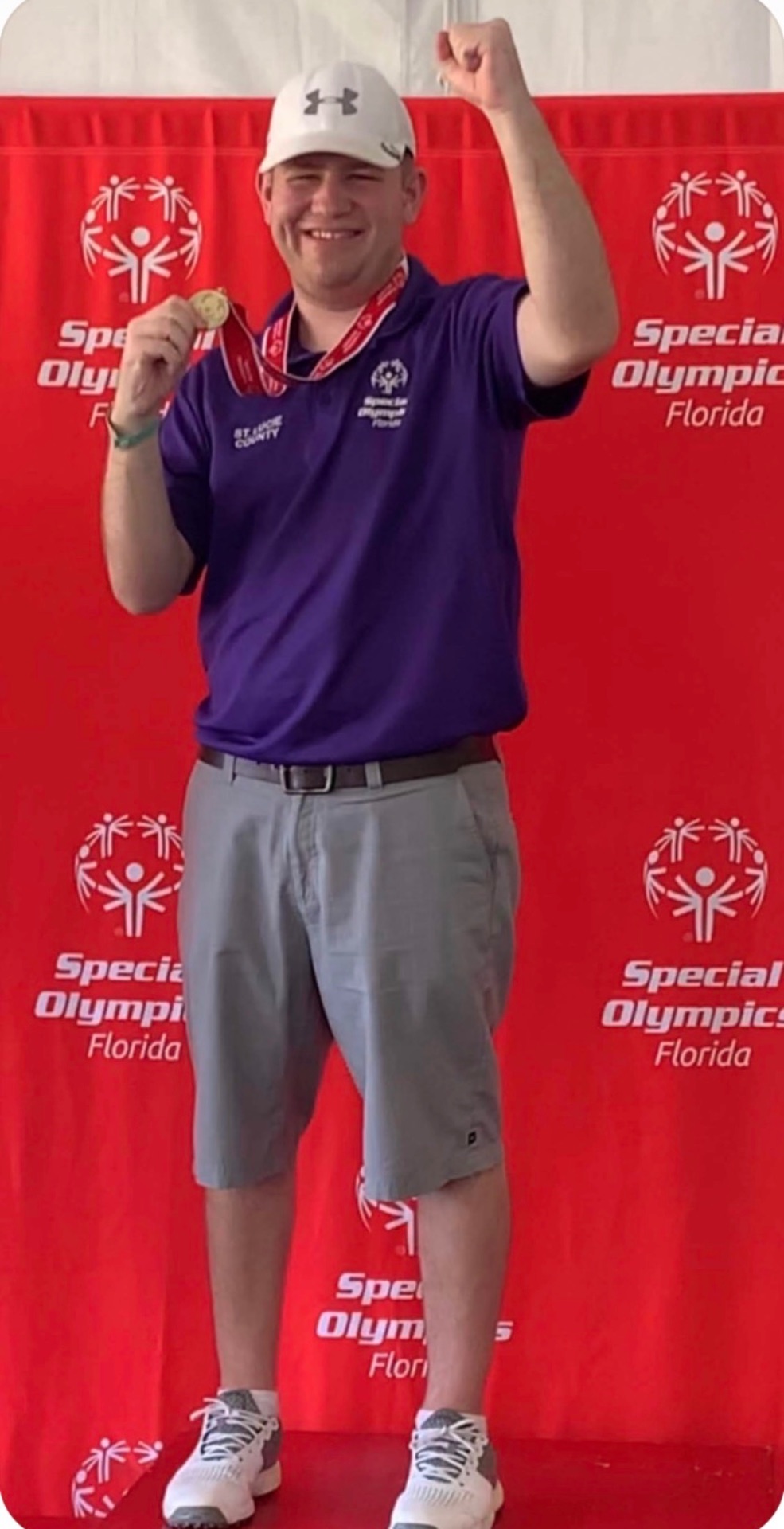 Stephen Lepore celebrating with a gold medal in front of a Special Olympics Florida backdrop